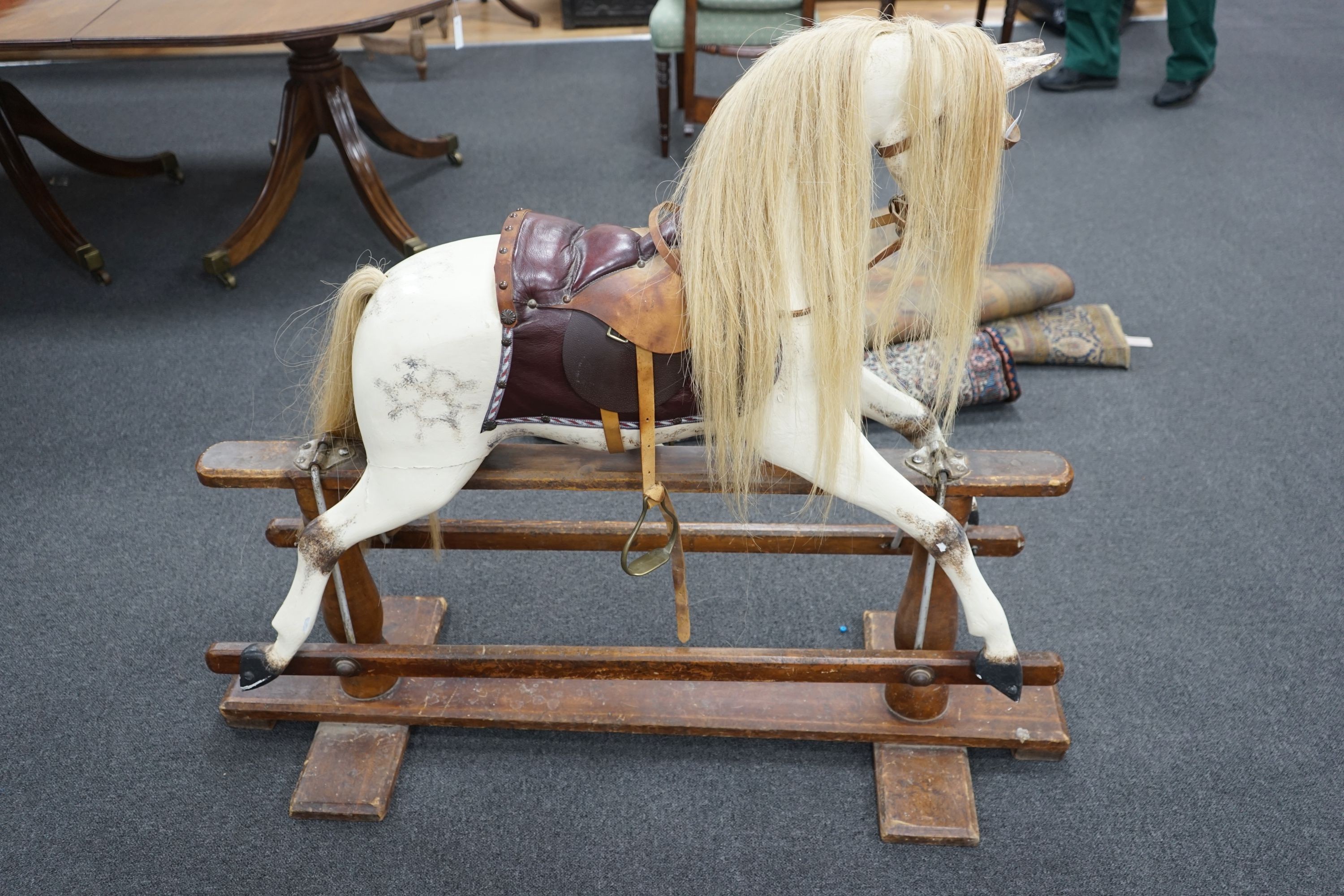 An early 20th century Ayres type dapple grey rocking horse on pine safety frame, width 130cm, height 110cm